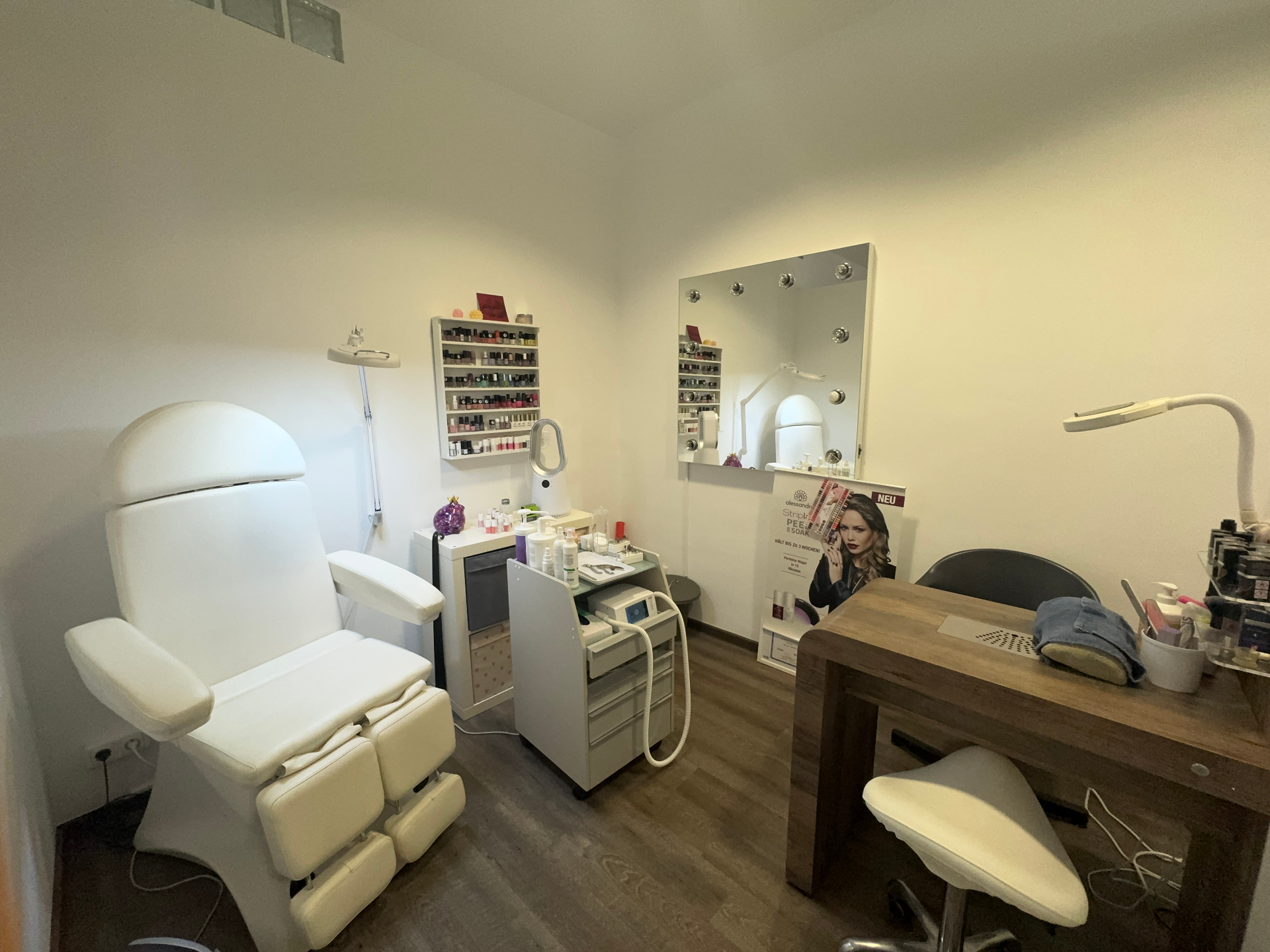 Nagelstudio-Bereich mit Maniküretisch und Lackregal